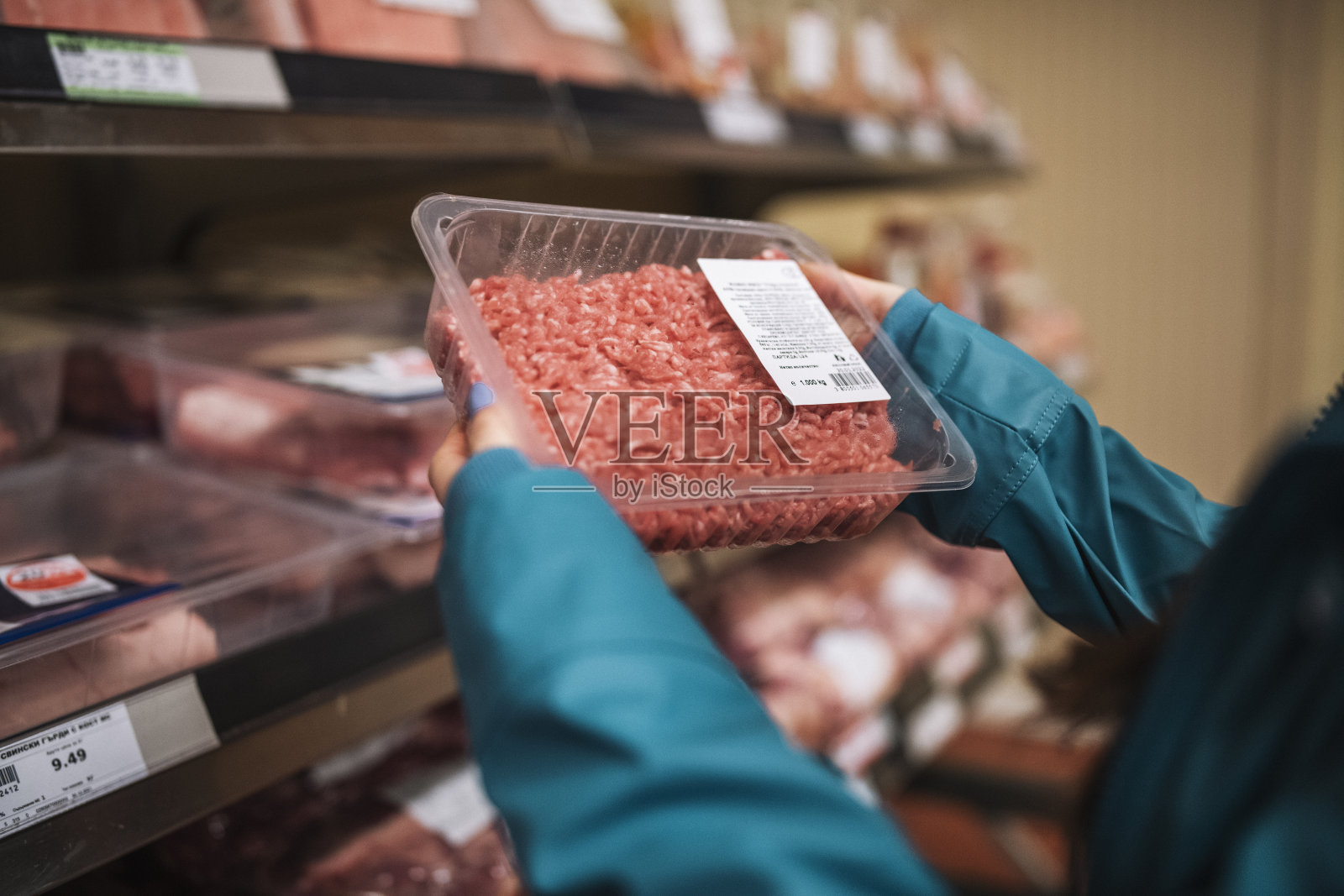 从超市购买新鲜肉末的妇女。照片摄影图片