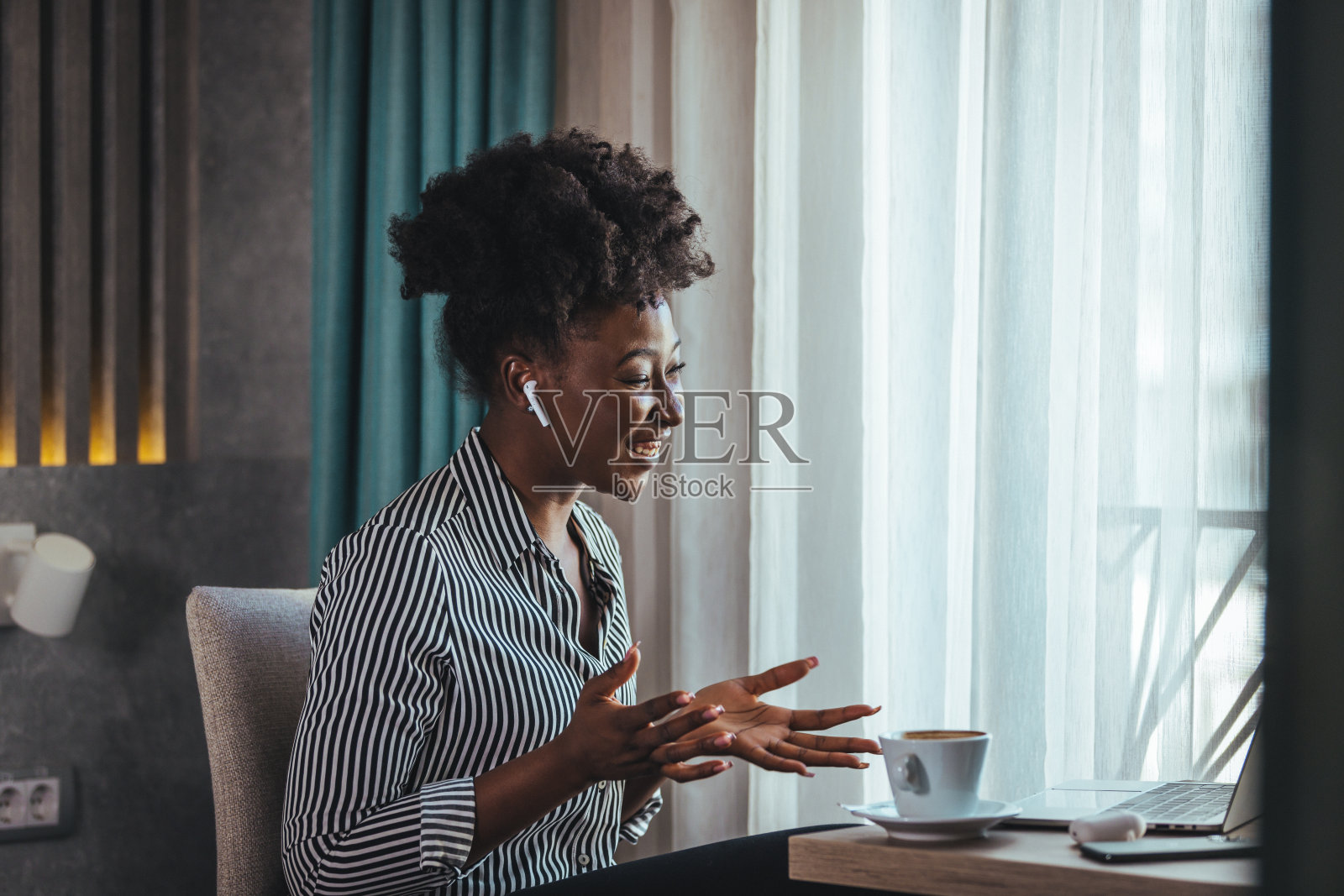 女人早上坐在床上喝咖啡。照片摄影图片