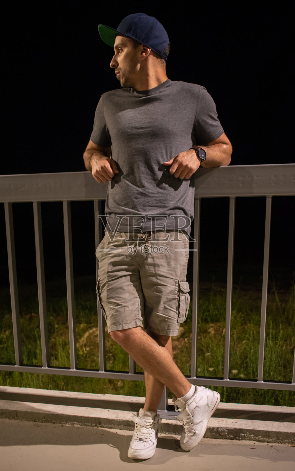 一个城市帅哥倚着桥的栏杆照片摄影图片