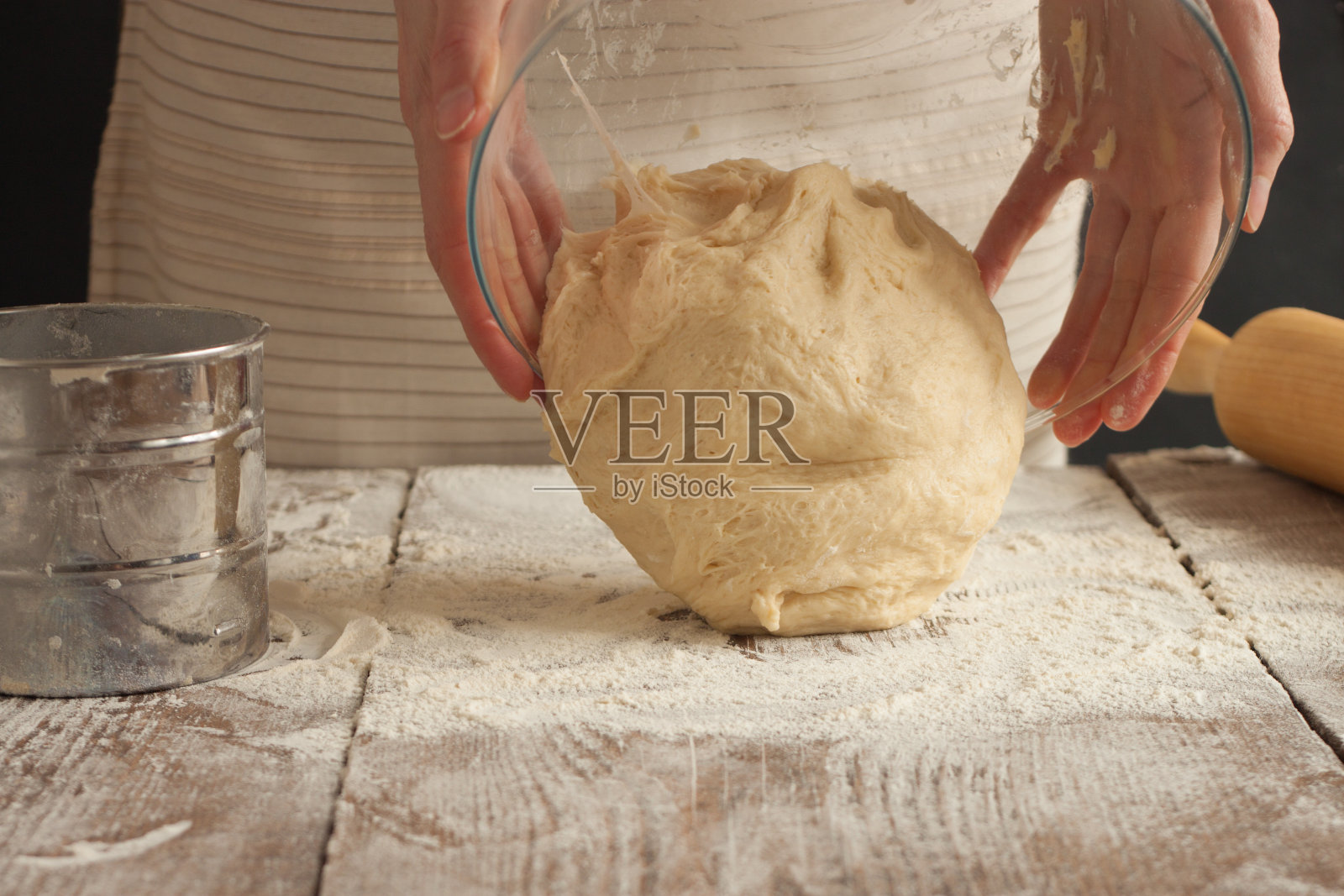 女人把生面团放在桌子上照片摄影图片