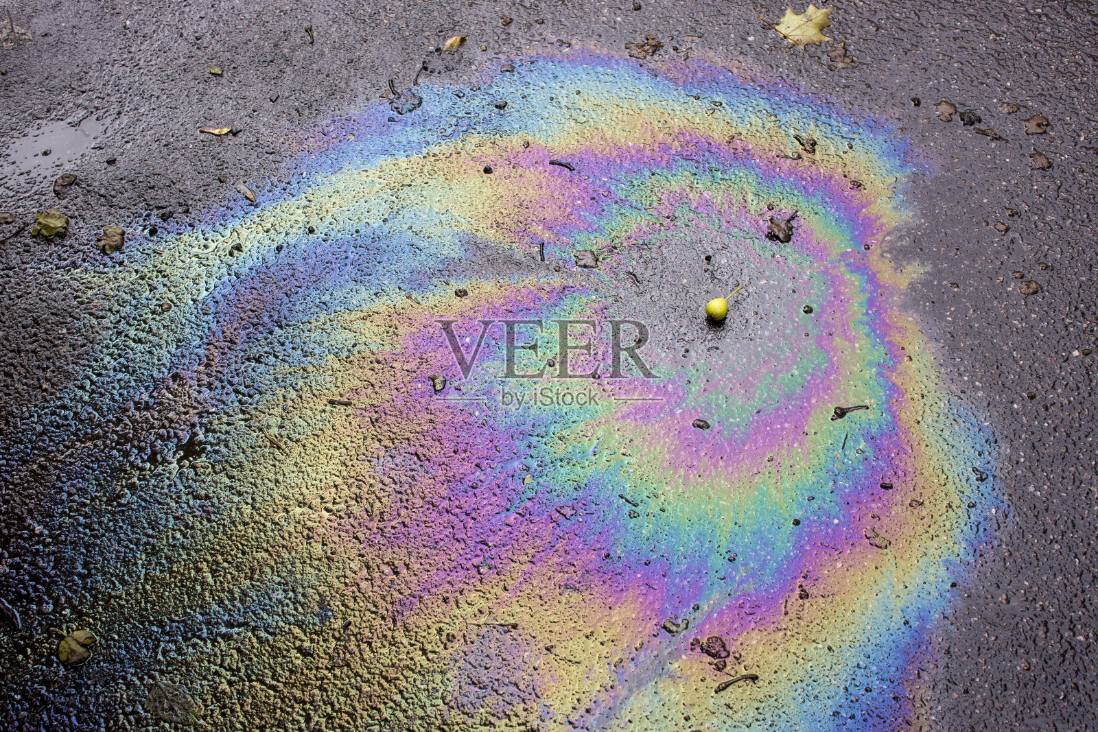 汽油的闪光斑点。沥青上的汽油就像一大滩被污染的水。彩虹般光滑的汽油照片摄影图片