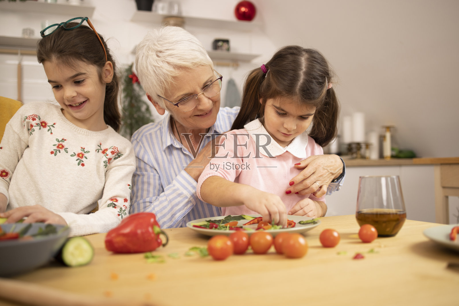一个快乐的老年妇女和她的两个孙女一起做午餐的肖像照片摄影图片