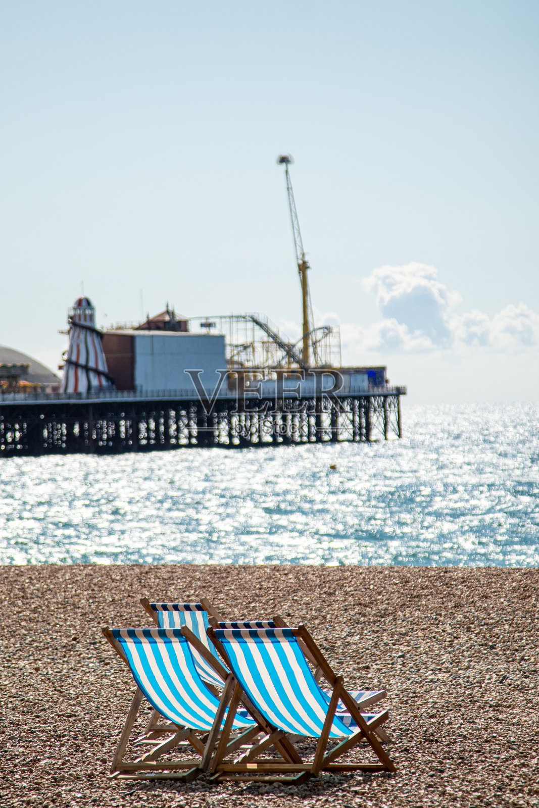 阳光明媚的一天，英国布莱顿海滩的条纹椅子照片摄影图片