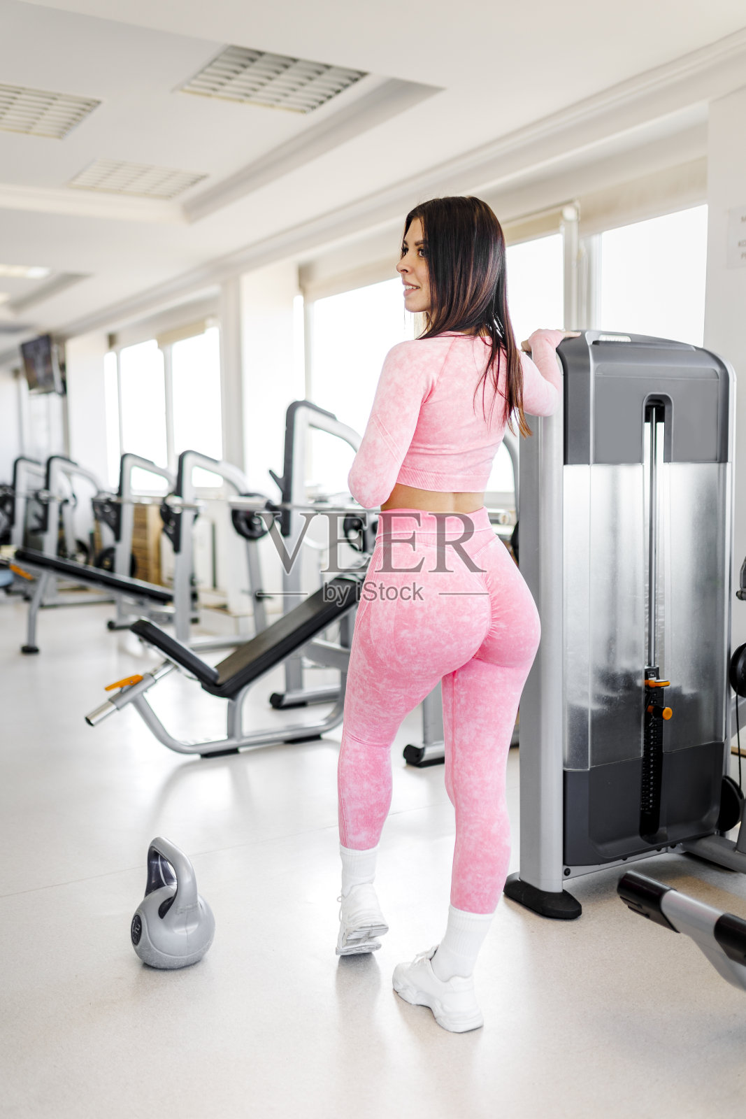 在健身俱乐部用壶铃锻炼的女运动员照片摄影图片