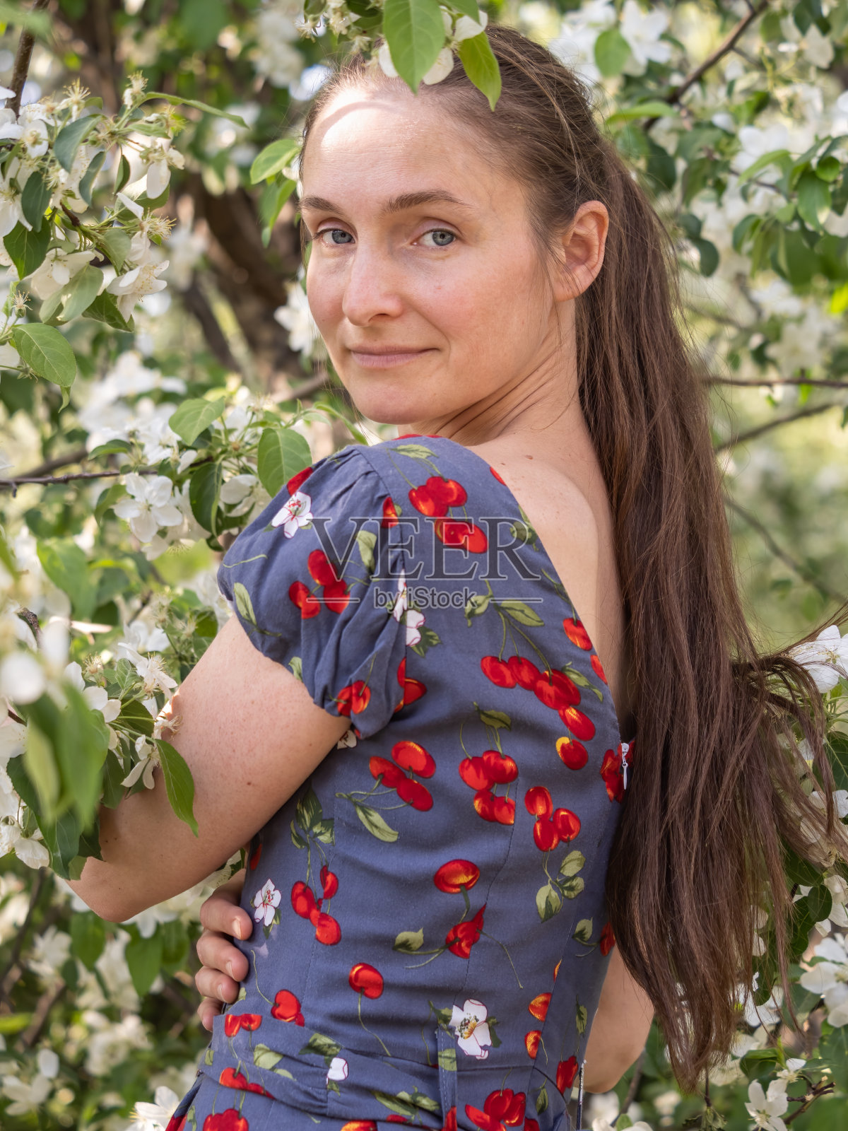 美丽的年轻女子没有化妆在春天公园的花树照片摄影图片