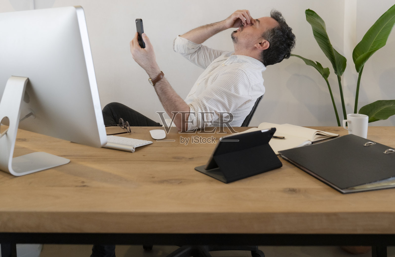 在办公室工作的商人看起来压力很大照片摄影图片