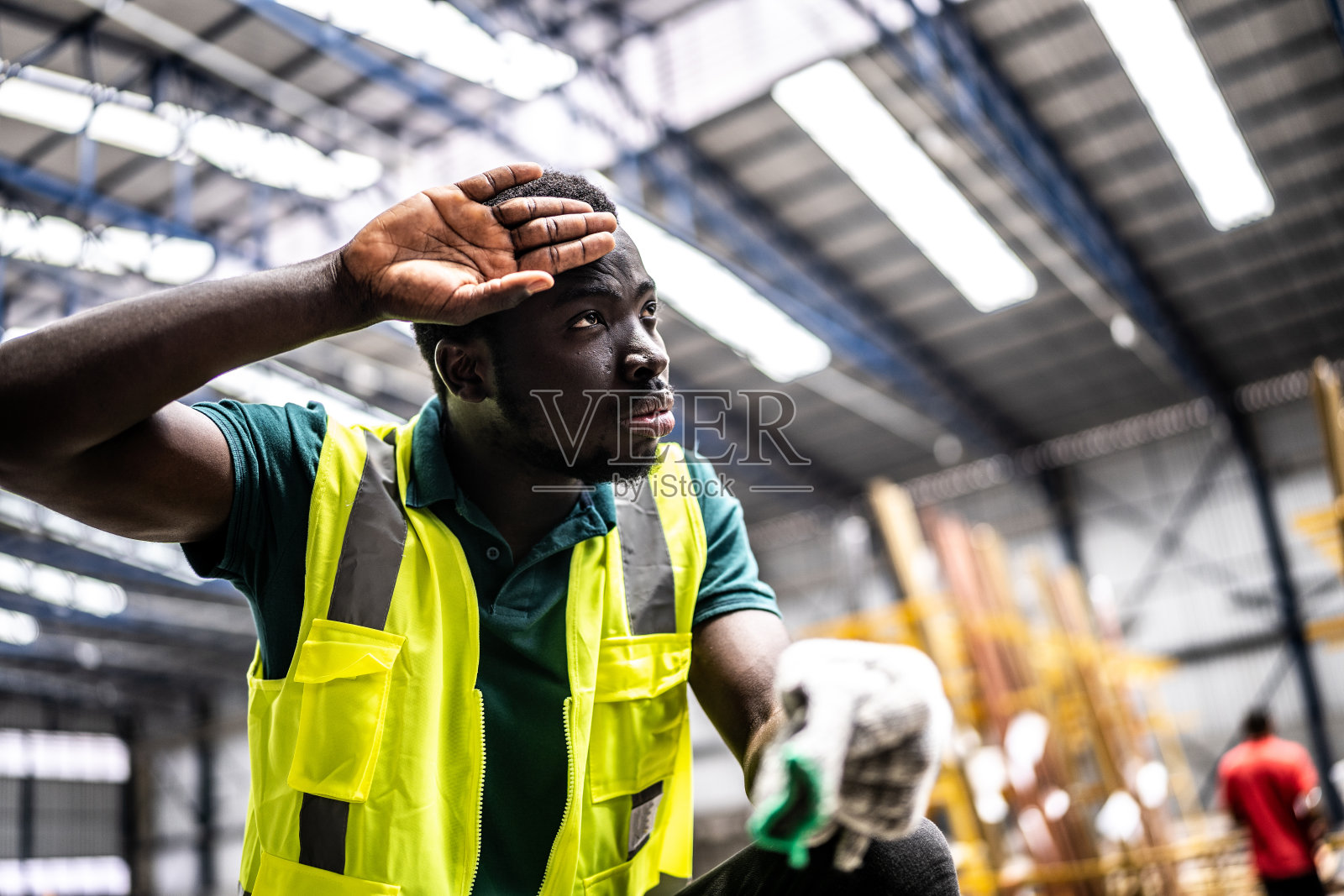 一个疲倦的年轻人在一家工厂工作照片摄影图片
