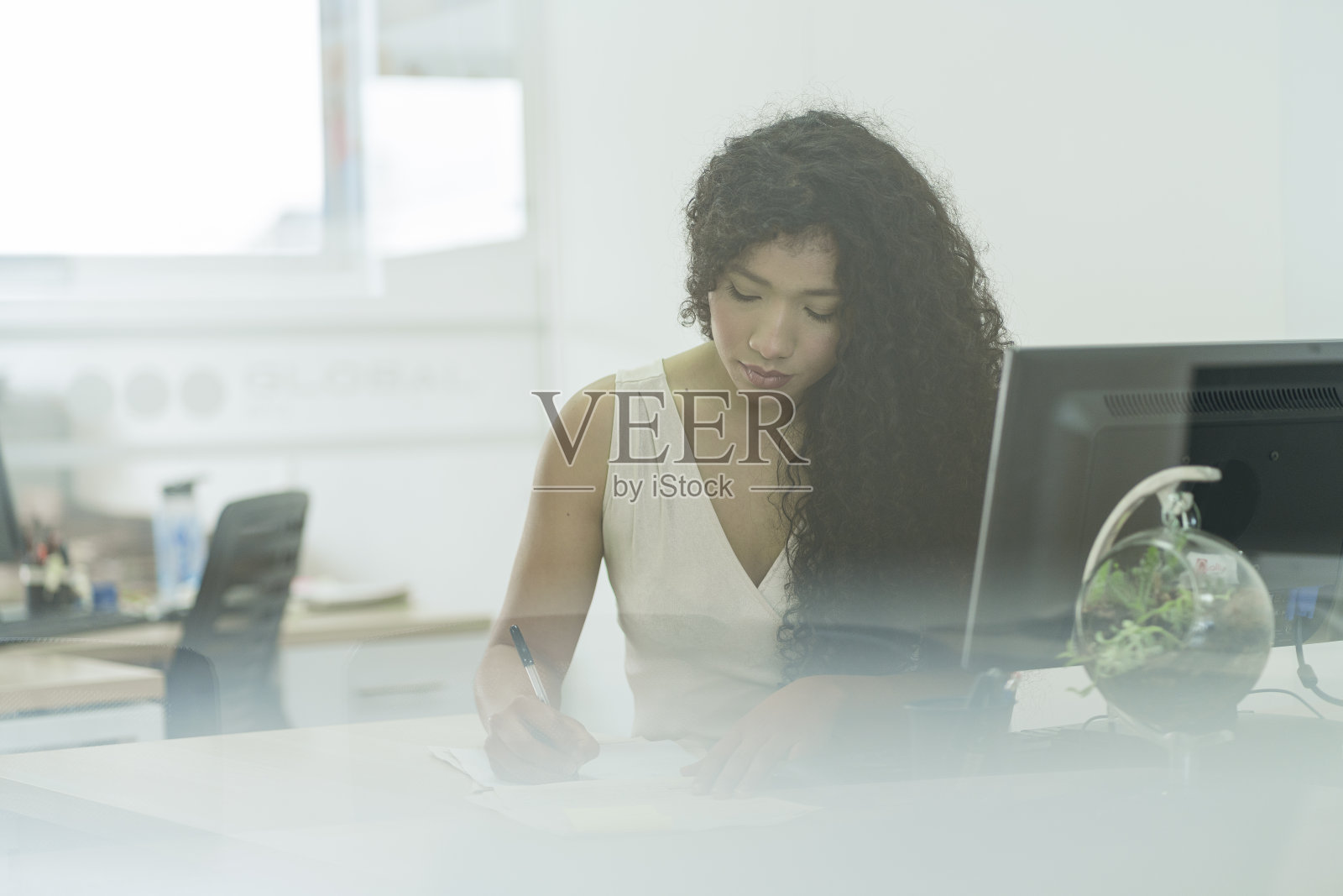 当客户想和她做生意的时候，非洲发型的女人在她的办公室里工作照片摄影图片