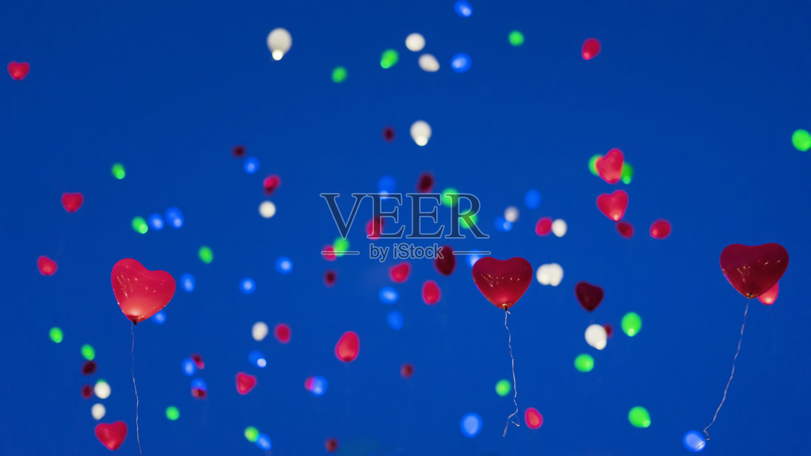 夜空中的彩色LED气球。浪漫风格的爱情观念，情人节的节日照片摄影图片