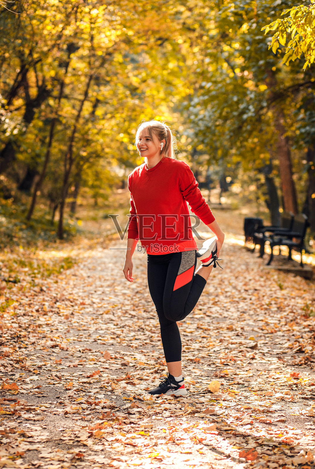 年轻女子在公园跑步前做热身和伸展运动。照片摄影图片