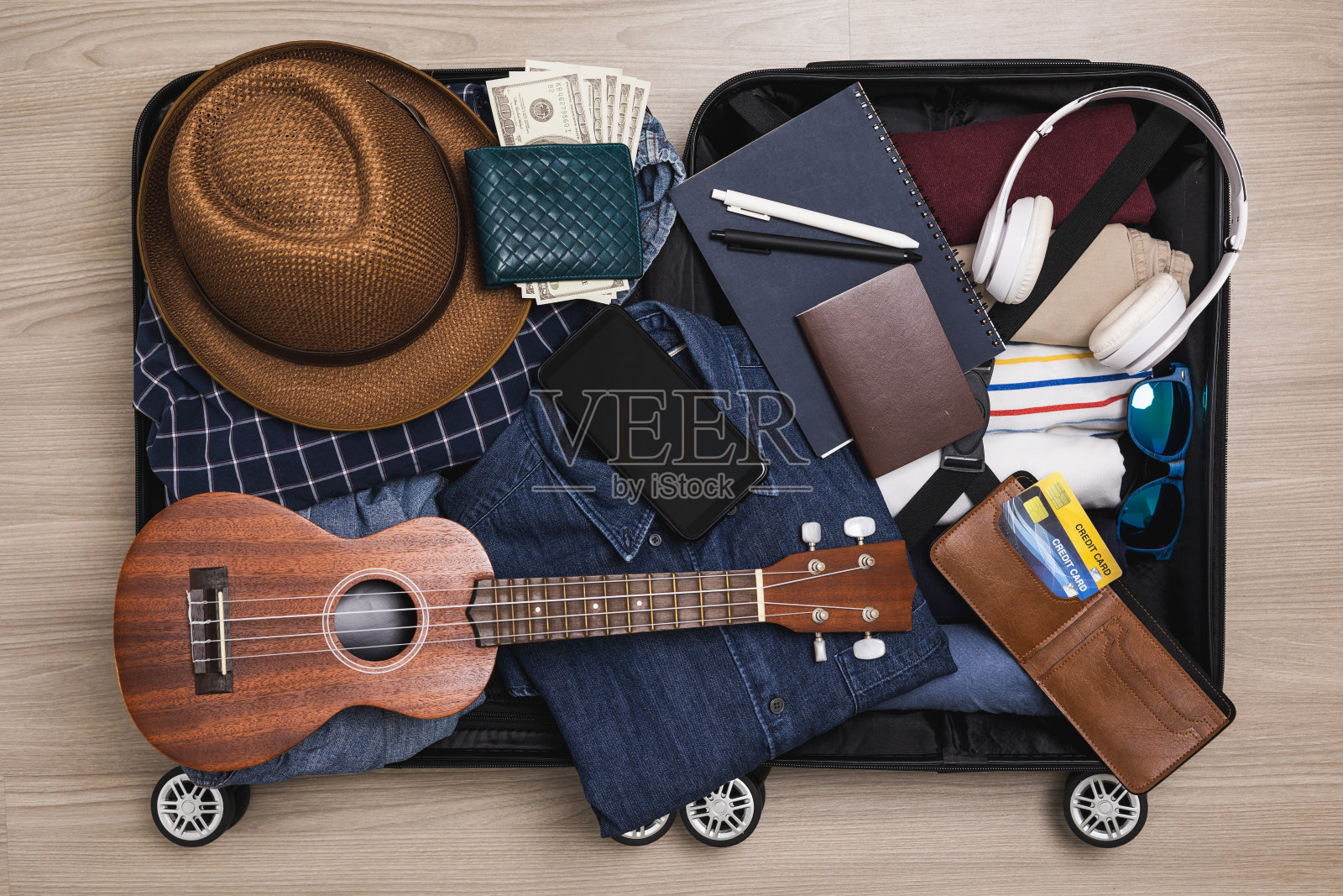 俯视图组织行李。把衣服和裤子放在手推车里，准备出国。为暑假旅行准备行李。旅行者配件，打开行李。照片摄影图片