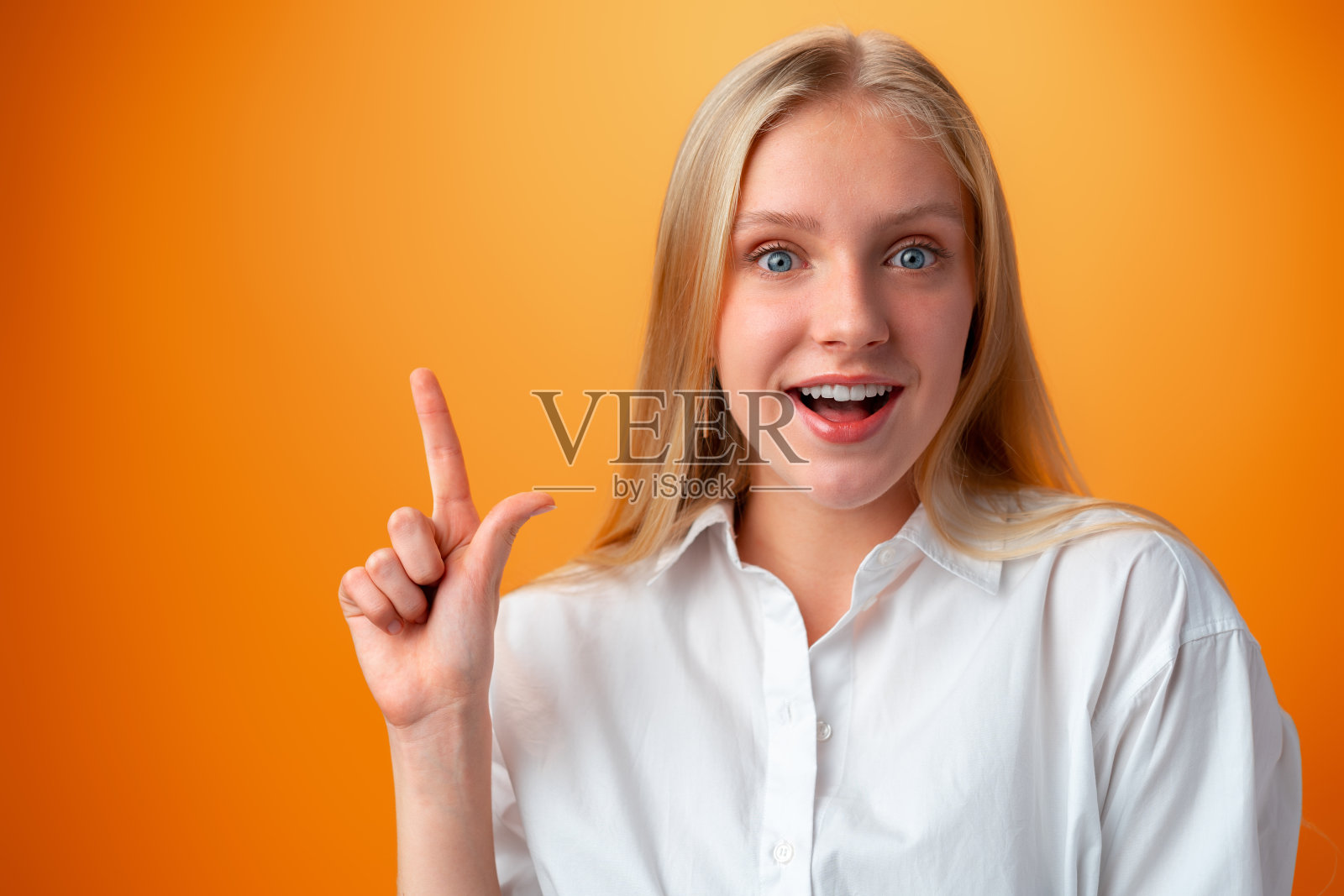 可爱体贴的少女肖像在橙色背景下照片摄影图片