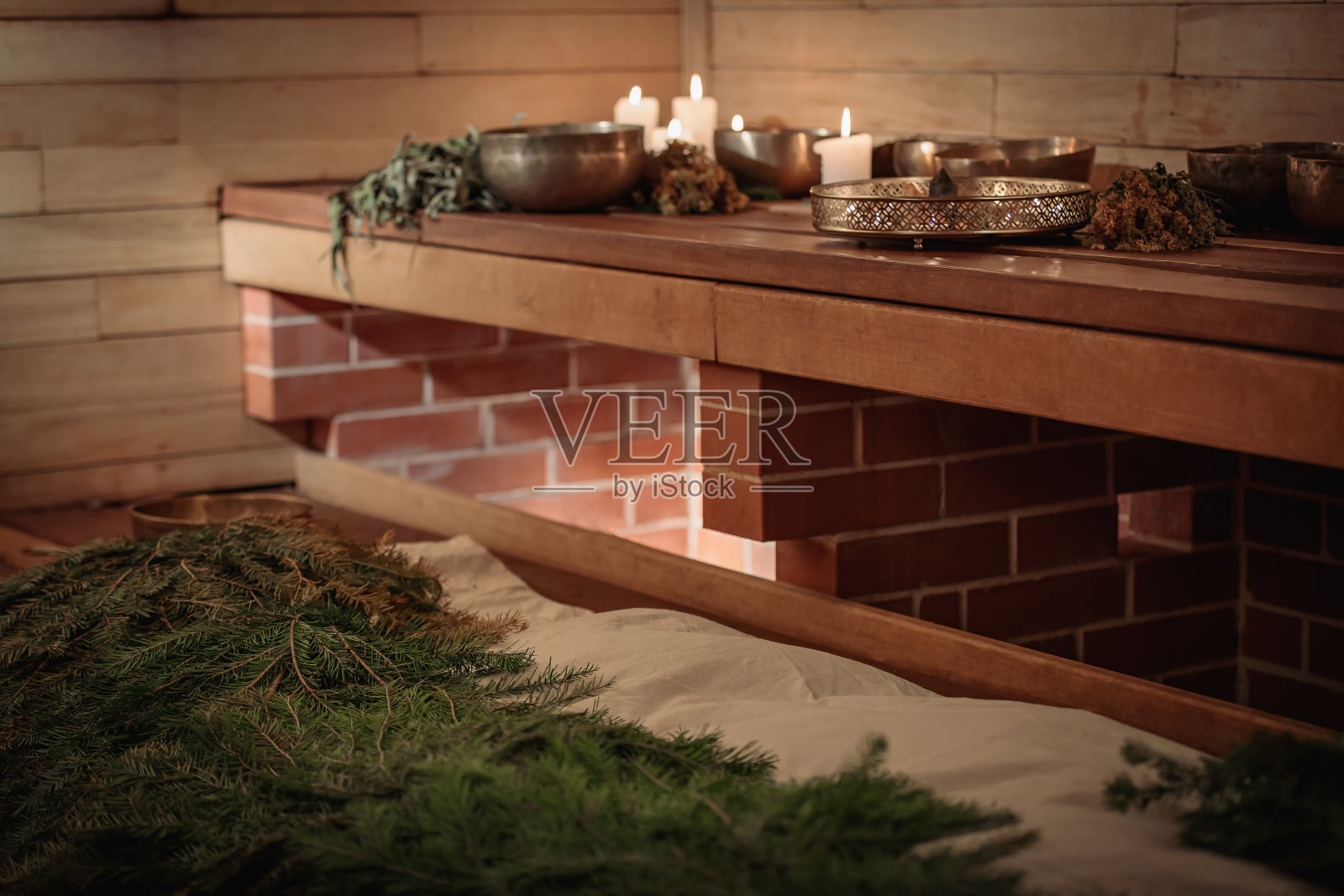 木质背景上的颂钵、干草束与蜡烛照片摄影图片