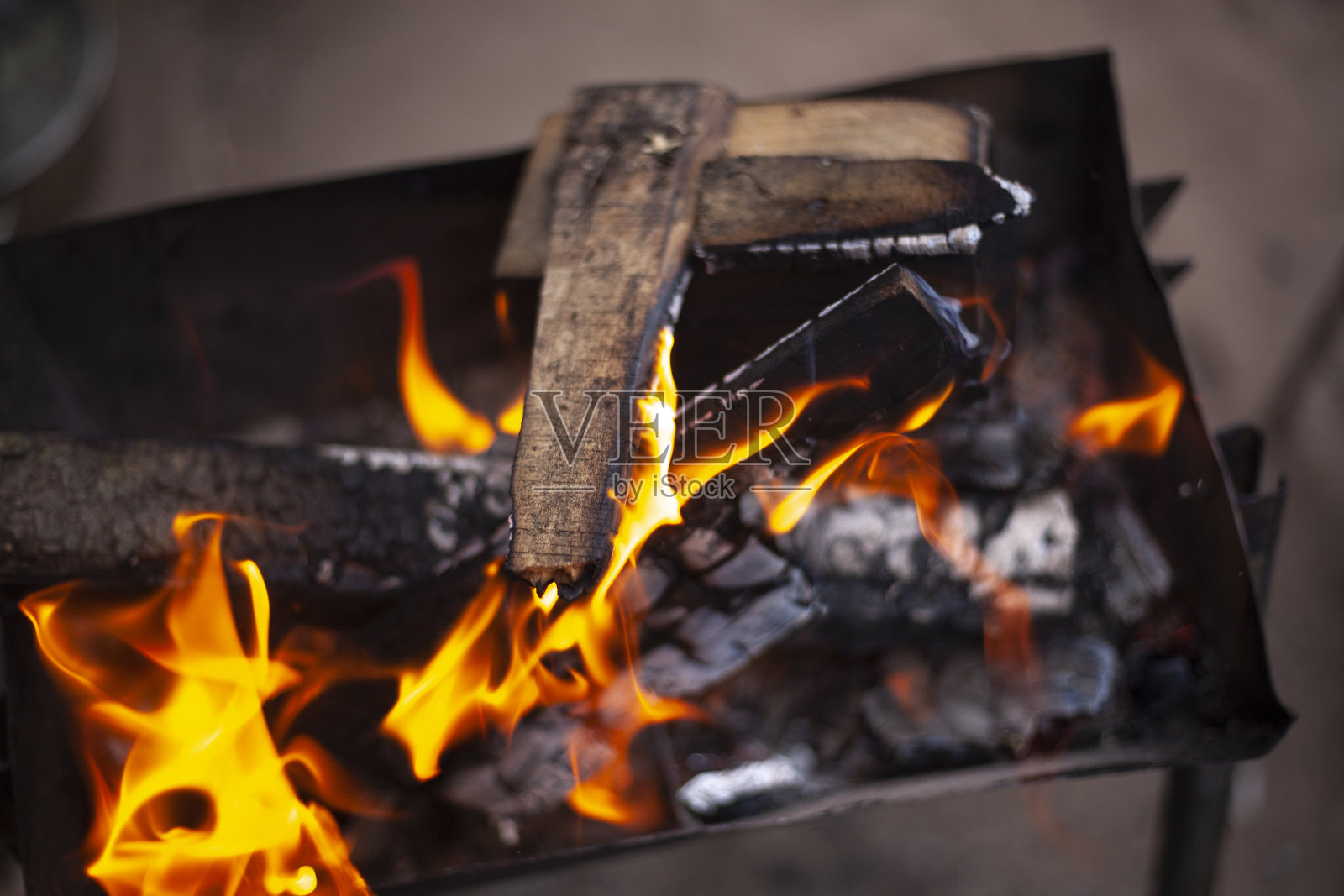 木柴燃烧。燃烧的干树枝。创建煤炭。野餐的细节。照片摄影图片