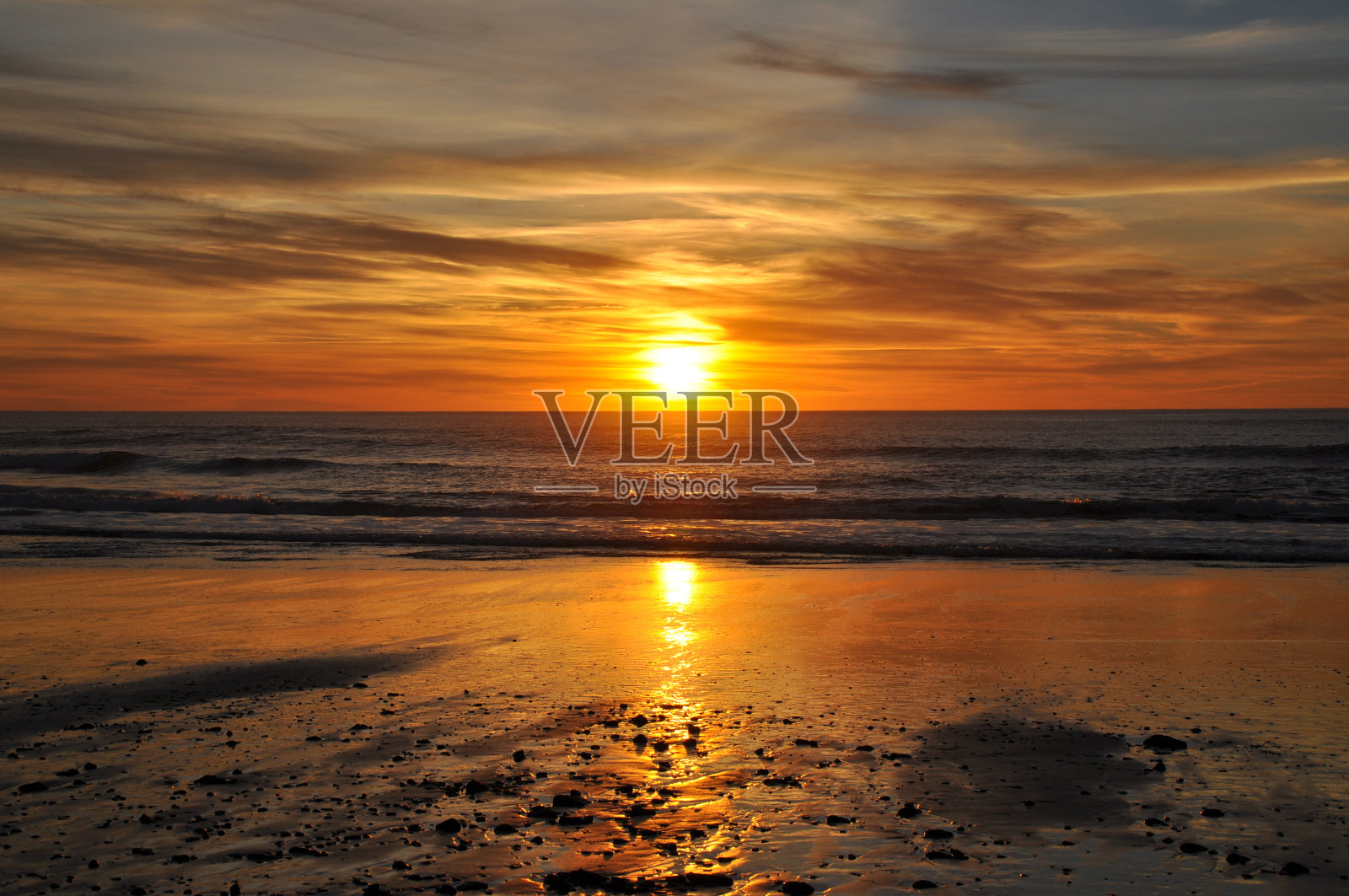 海滩上明亮的橙色日落照片摄影图片