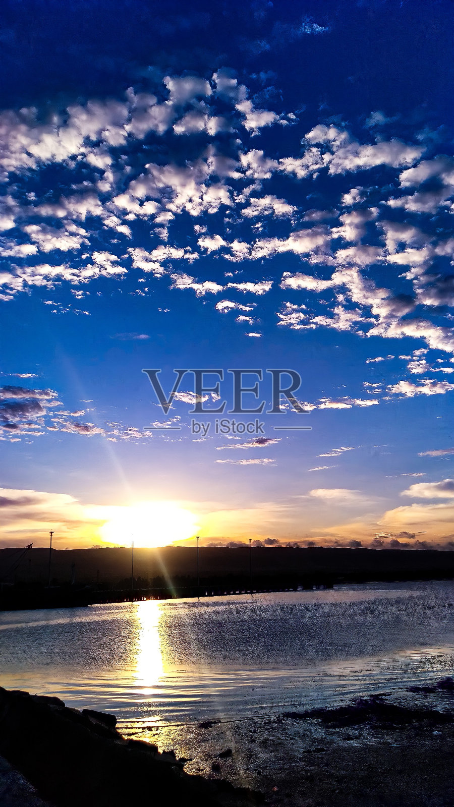 码头上的日落，美丽的云朵点缀着蓝色和橙色的天空——松巴岛，2021年6月照片摄影图片