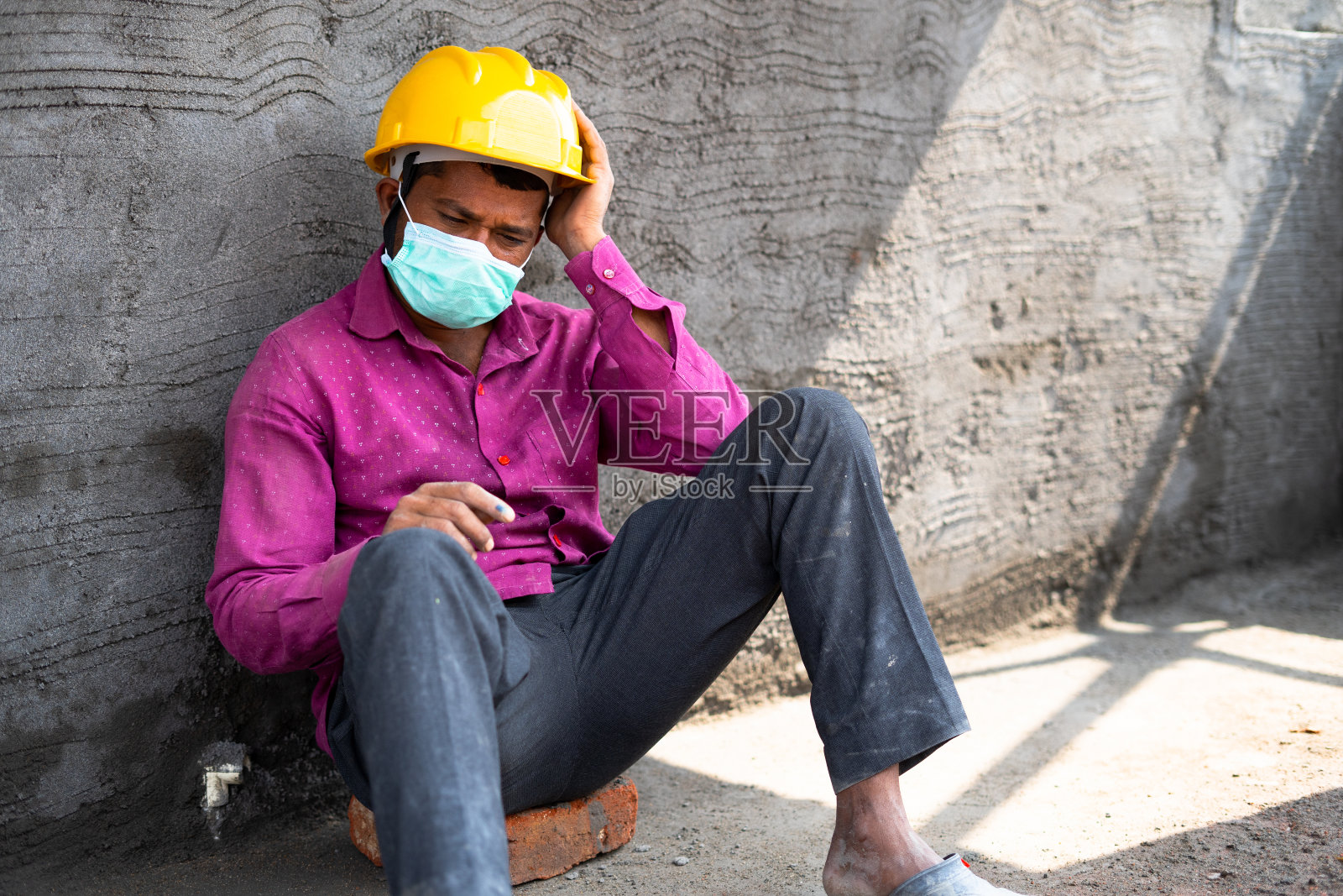 潘石屹手持镜头拍摄的是戴着口罩的建筑工人在现场焦虑不安的情景——在冠状病毒或covid-19大流行封锁期间，失业、负债和孤独的概念照片摄影图片