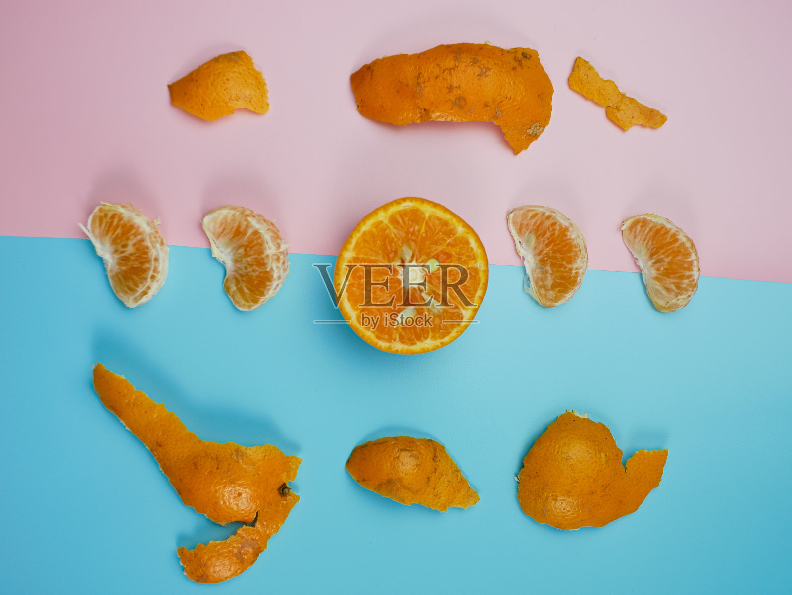 创意概念从橙色上的蓝色和粉红色的柔和背景。健康和最小的水果概念照片摄影图片