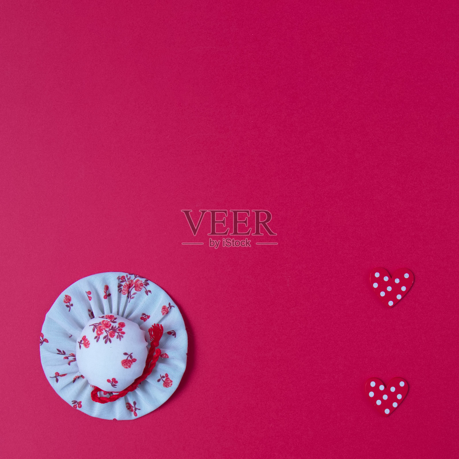 女孩的帽子结合了两个点的心在红色的背景与复制空间。平铺极简的场景。照片摄影图片