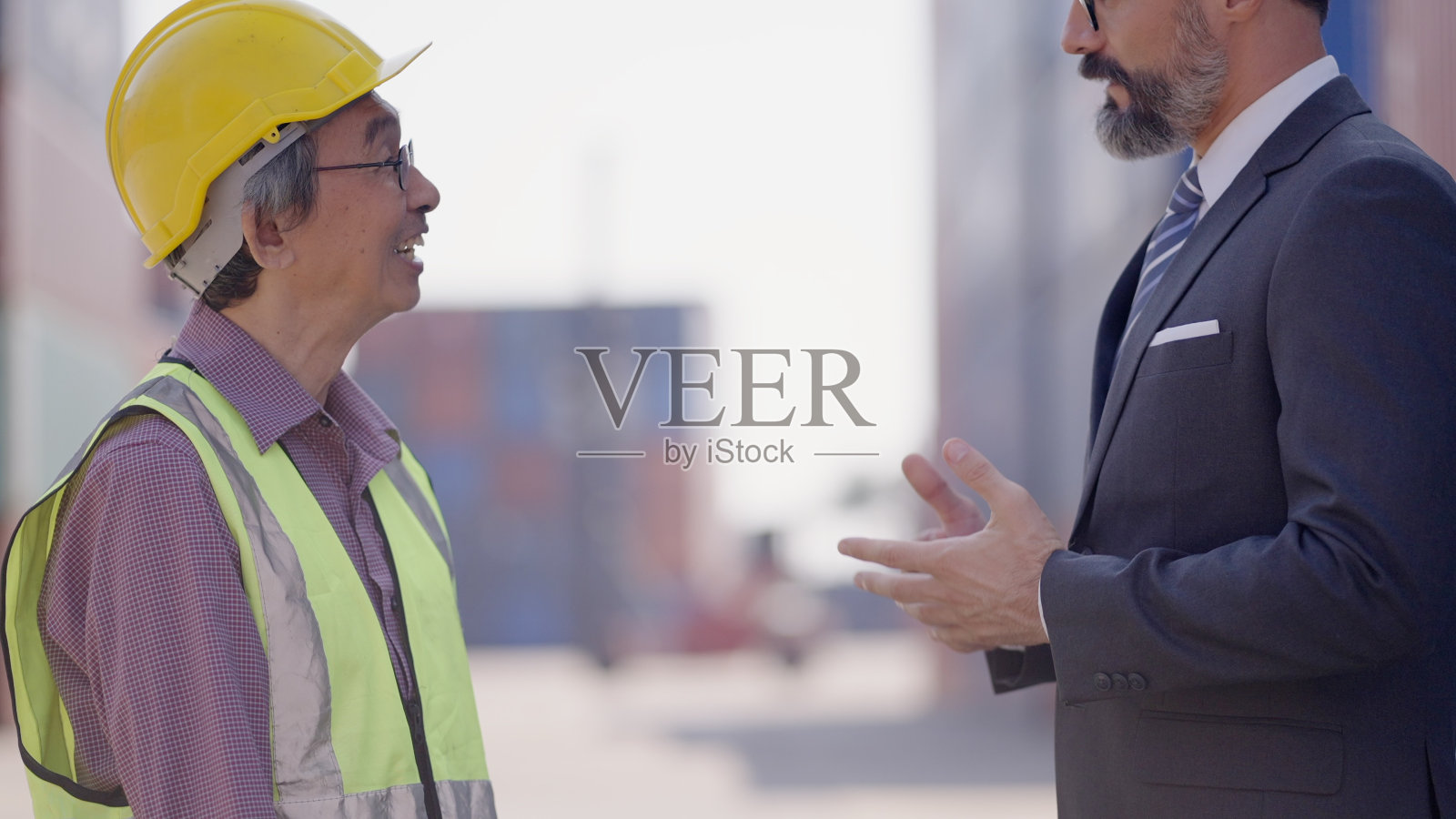 专业投资者或高管、经理在集装箱堆场与高级工程师共同商讨商业计划、工作流程或对新项目的投资达成一致。照片摄影图片