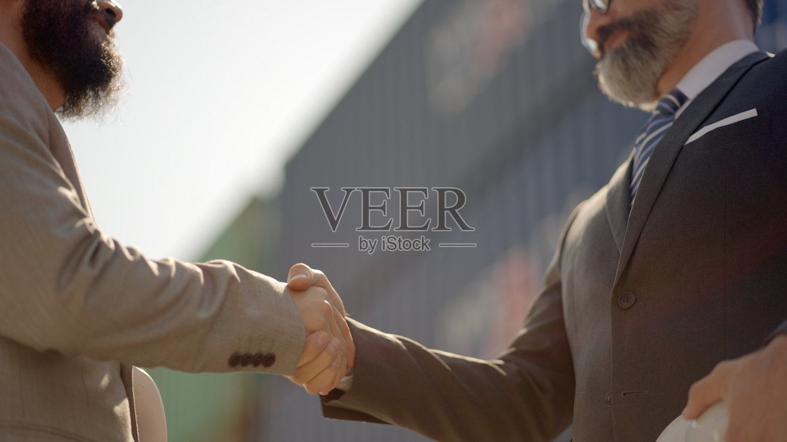 关闭了。商人是物流业务的合作伙伴，握手寒暄。投资者在集装箱装卸场对交易成功或新项目有约定投资时祝贺照片摄影图片