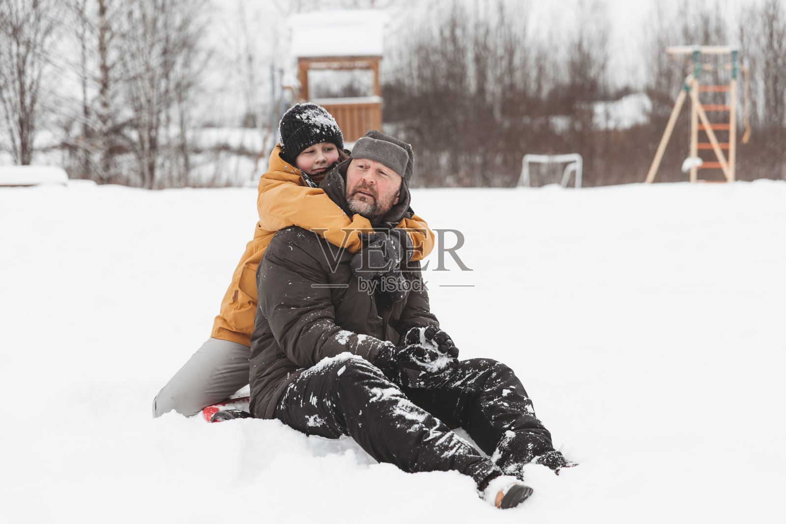 父亲和女儿走在雪原，一家人在冬季公园散步。照片摄影图片