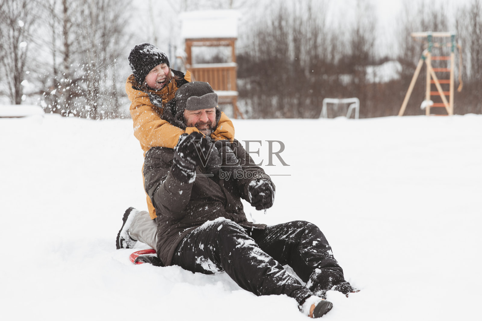 父亲和女儿走在雪原，一家人在冬季公园散步。照片摄影图片