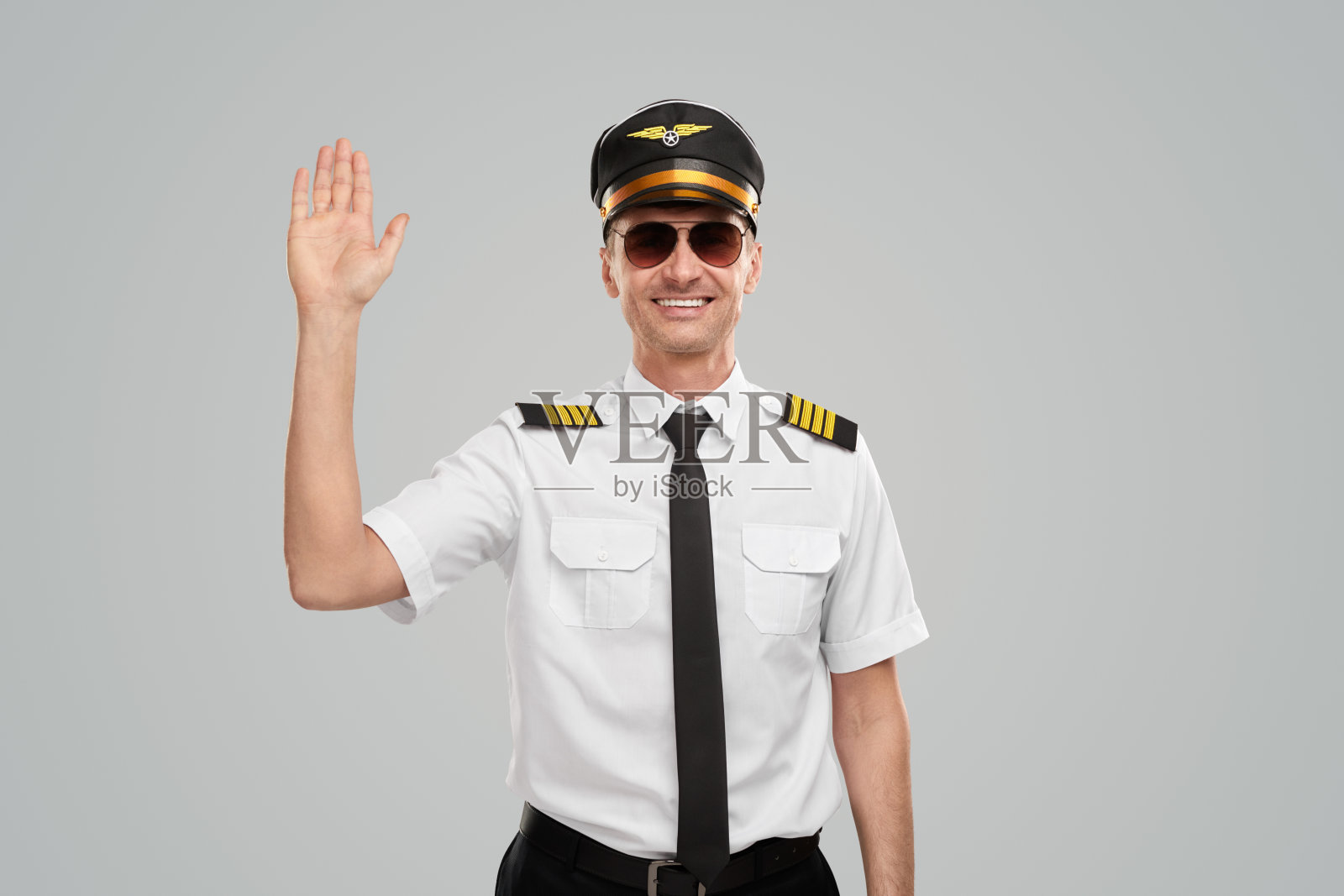 微笑着挥手的飞行员在演播室照片摄影图片