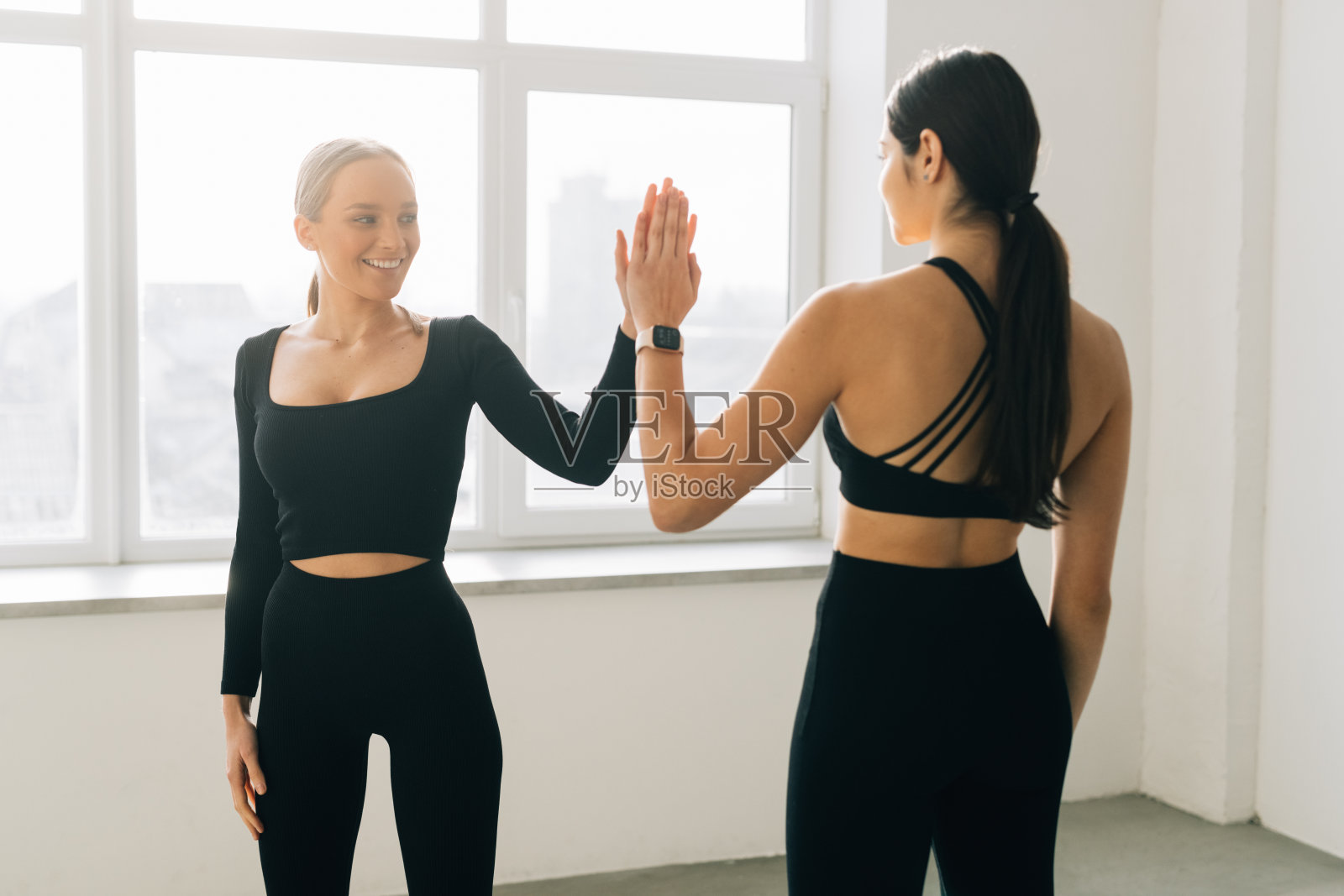 健身后，一位年轻健康的女士与朋友击掌照片摄影图片