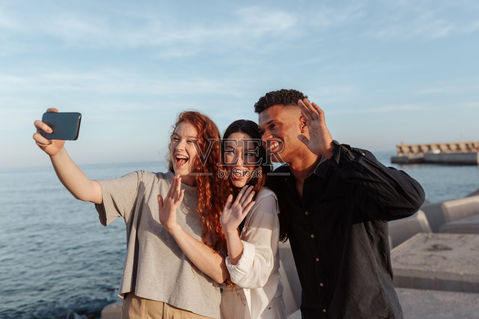 兴奋的年轻人在视频通话中向他们的朋友挥手照片摄影图片