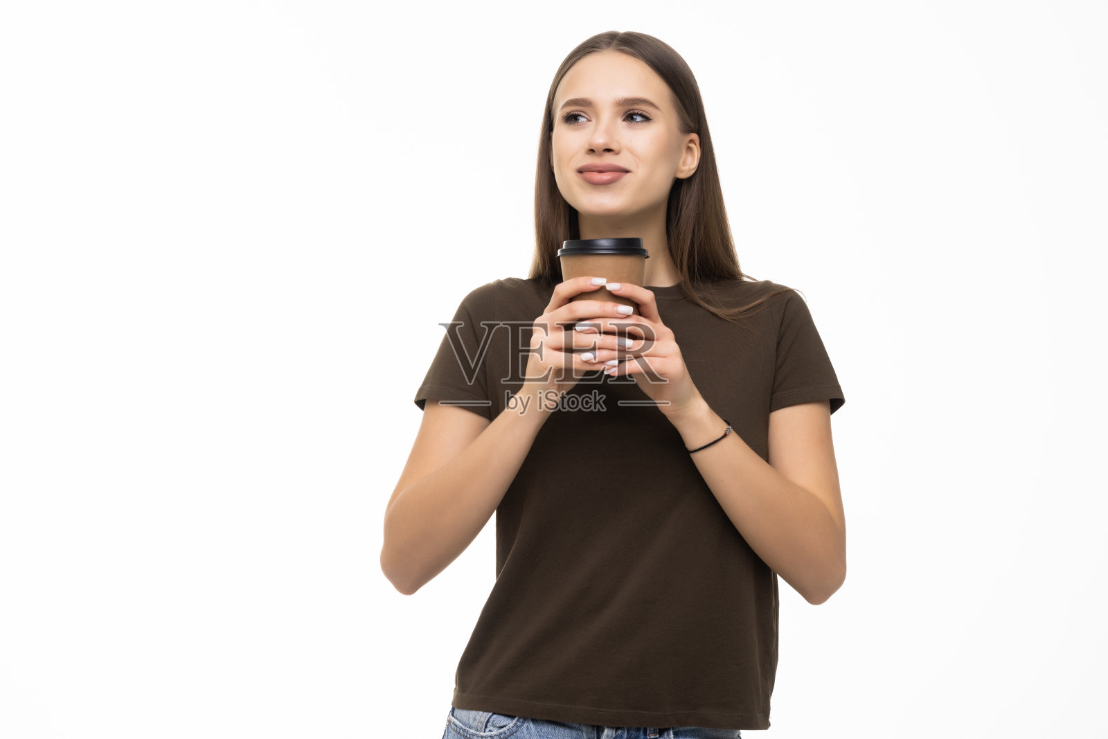 年轻女子端着一杯咖啡走着，在白色的背景上踽踽独行照片摄影图片