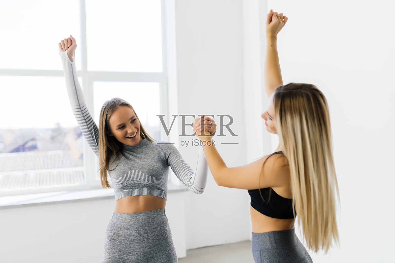 健身女性在锻炼过程中微笑着举手击掌。照片摄影图片