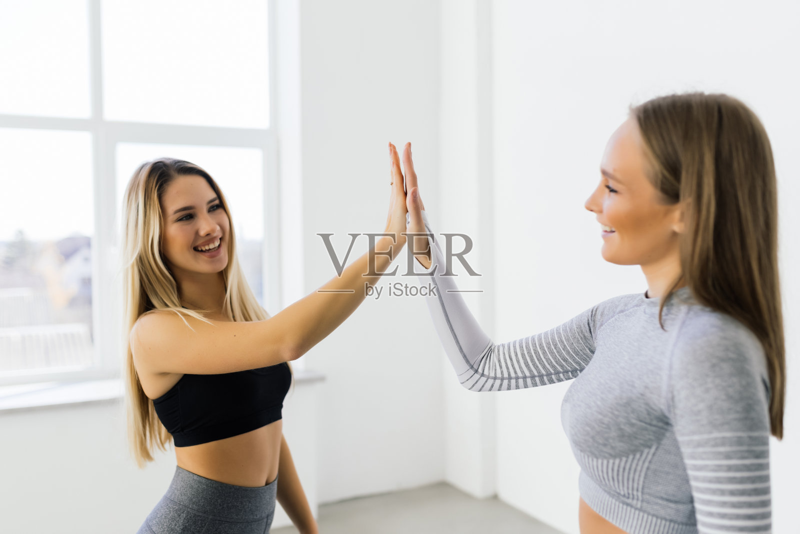 健身女性在锻炼过程中微笑着举手击掌。照片摄影图片