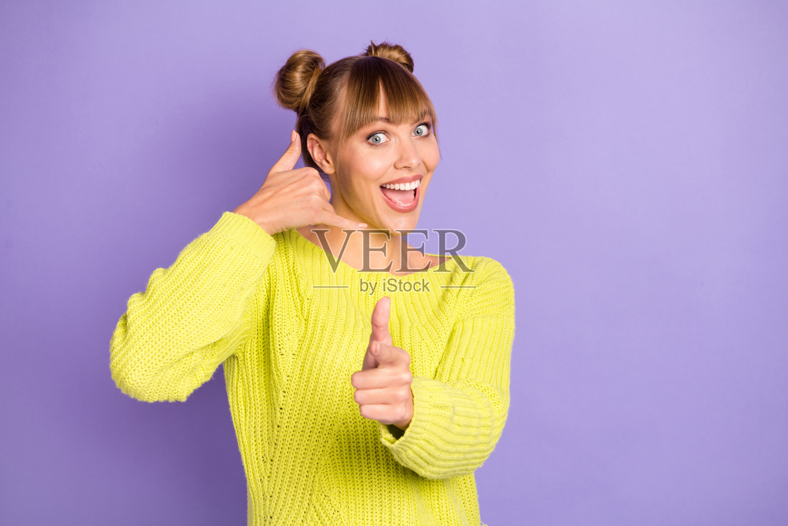 可爱的快乐的女孩显示电话标志指向你的特写肖像孤立的紫色背景照片摄影图片