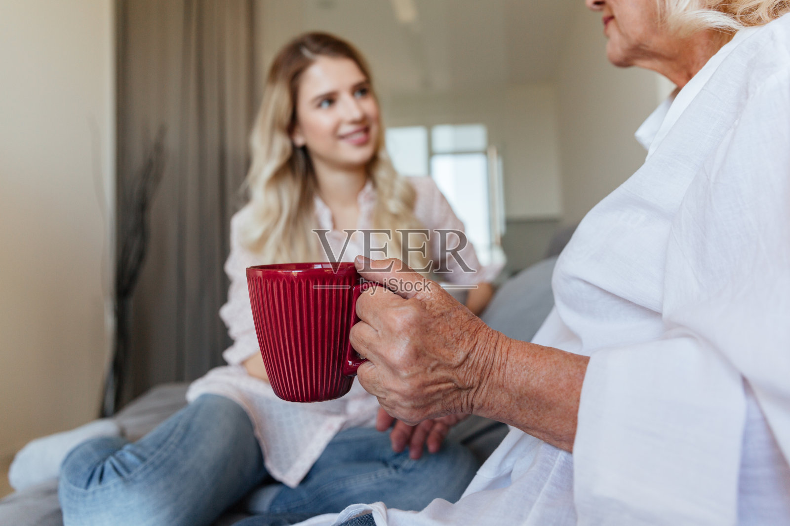 快乐的年轻女士和她的祖母坐在家里照片摄影图片