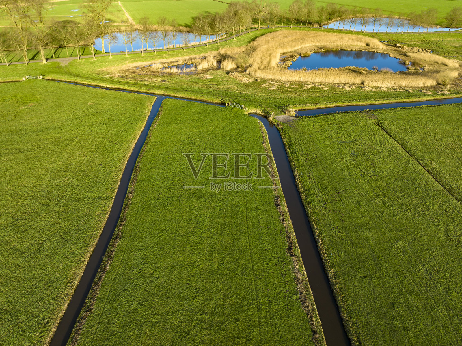 从上面看，沟渠穿过绿色的草地照片摄影图片