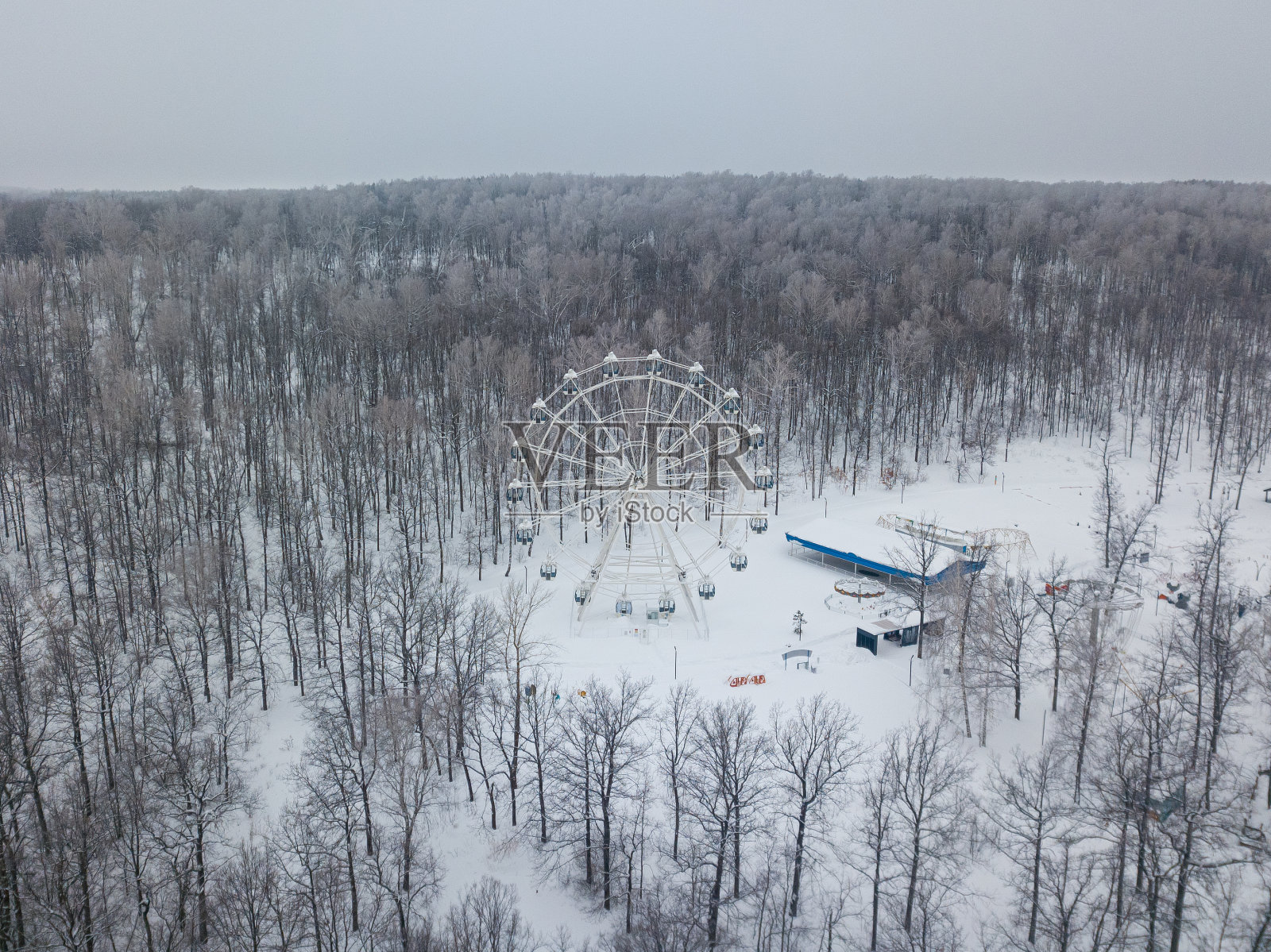 冬季小山上的树林里的摩天轮。从上面的观点照片摄影图片