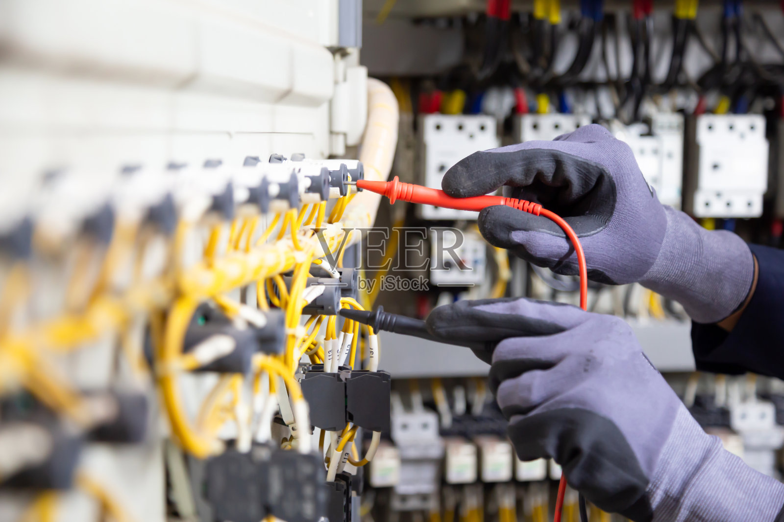 电工工程师在继电保护系统上测试电气装置和电线。电气设备自动化控制方案的调整。照片摄影图片