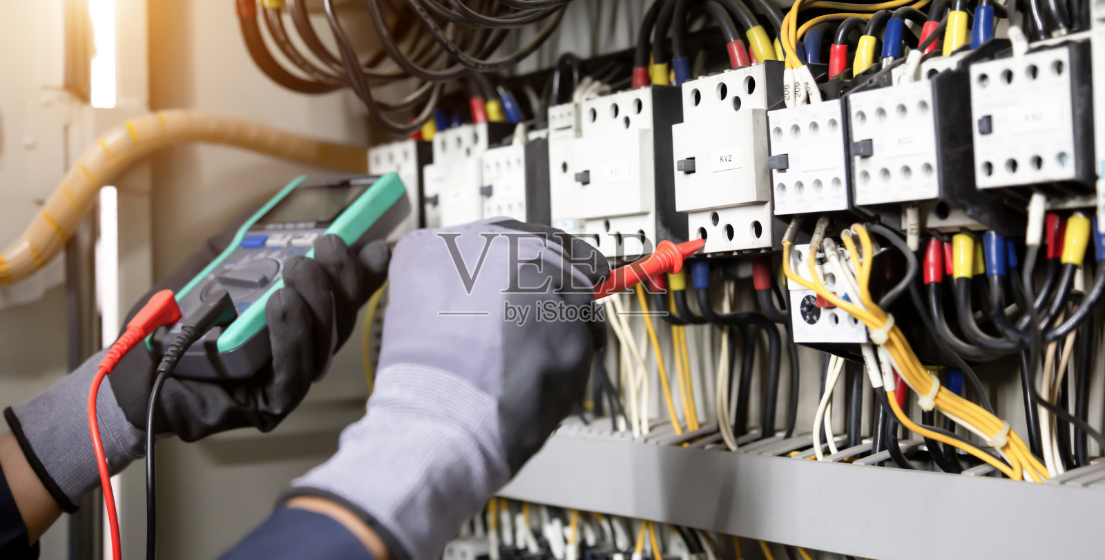 电工工程师在继电保护系统上测试电气装置和电线。电气设备自动化控制方案的调整。照片摄影图片