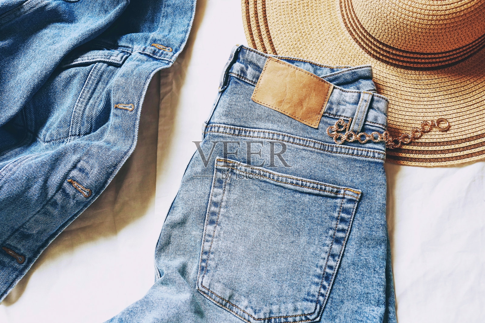 新潮时尚的全牛仔外观。蓝色夹克，高腰牛仔裤，草帽，黄色金属手链。夏季时尚时尚女性衣柜。平把照片照片摄影图片