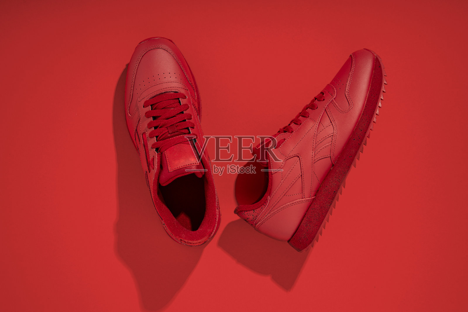 在红色背景上清洁红色运动鞋。俯视图，平躺。照片摄影图片