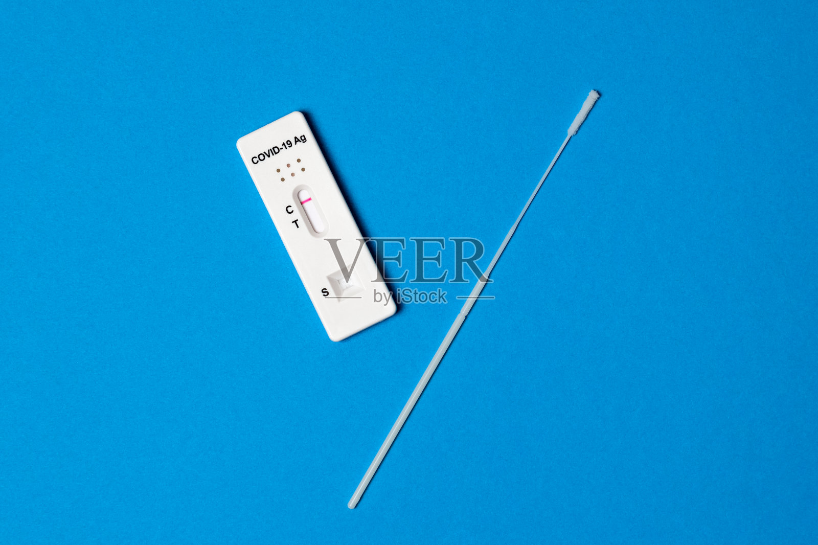 用新型冠状病毒肺炎(COVID-19)分离物快速检测仪在蓝色背景下手持阴性结果。诊断家中冠状病毒感染照片摄影图片