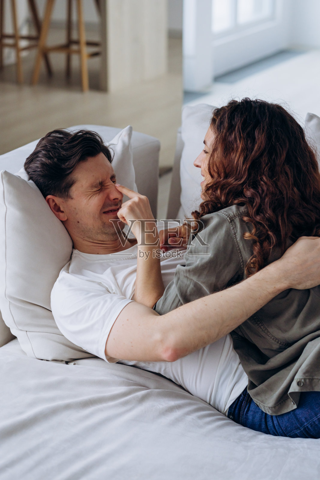 新婚夫妇在客厅的沙发上搔痒和躺着玩得很开心照片摄影图片