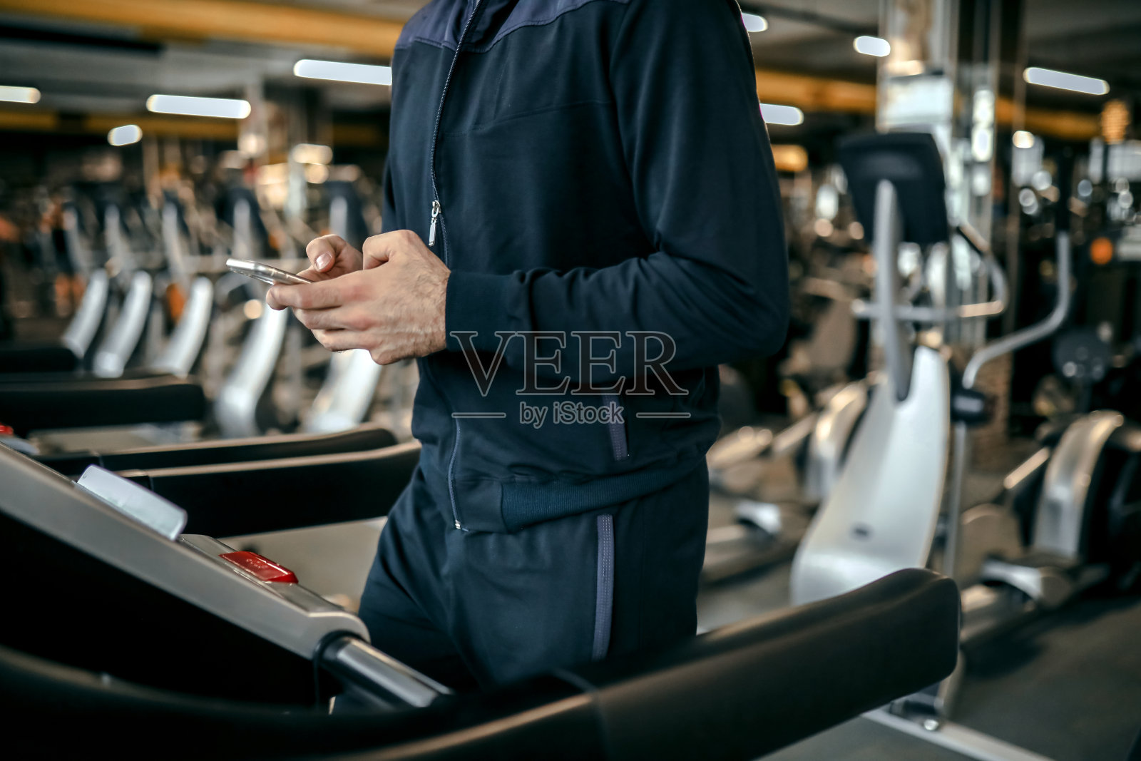 在跑步机上锻炼，用手机使用科技照片摄影图片