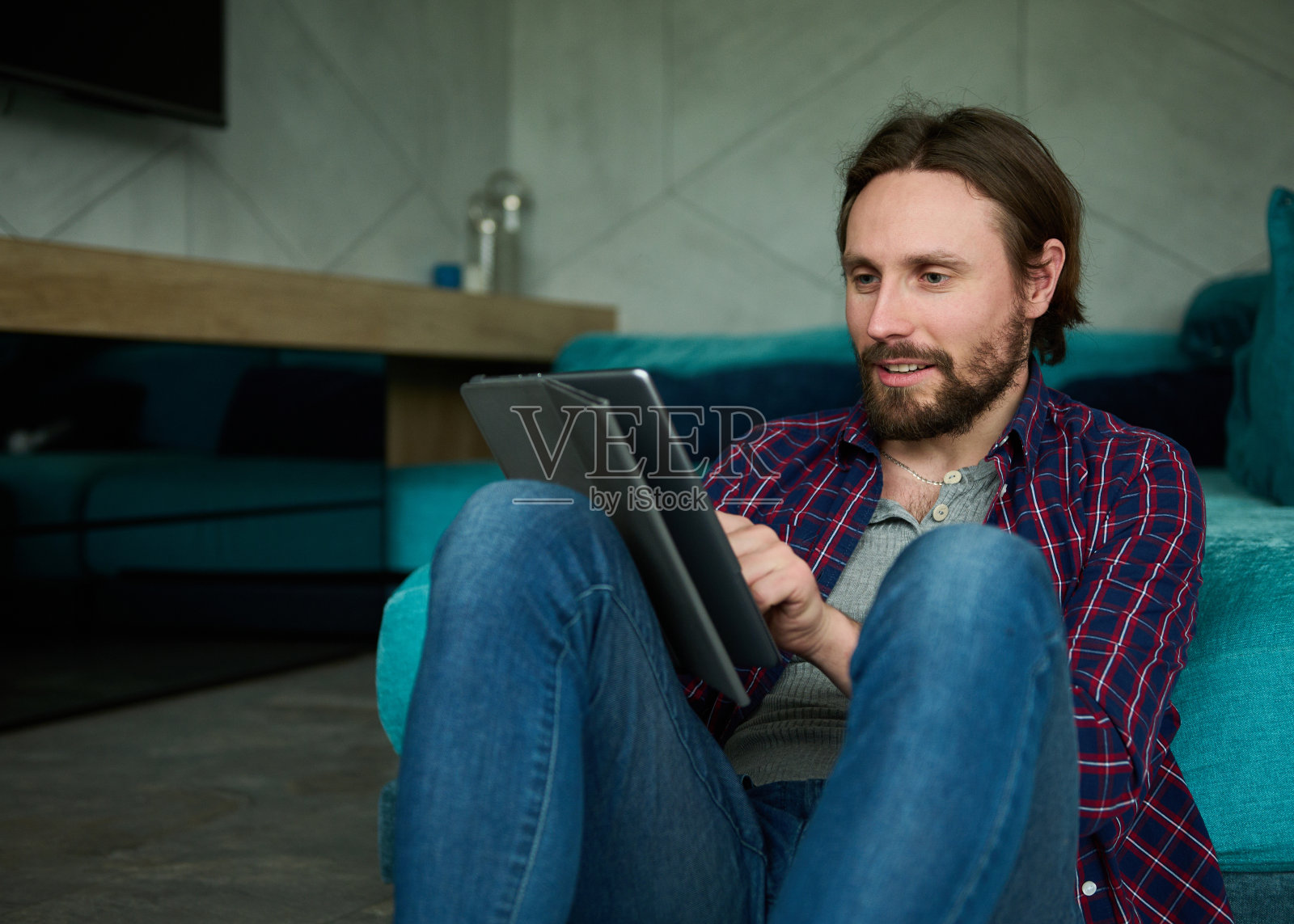 年轻白人，自由职业者，在家用数码平板电脑。男性企业家在社交媒体应用上阅读新闻。在线营销，电子商务业务。照片摄影图片