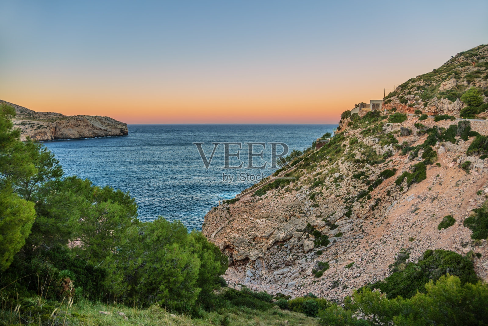 美丽的粉红色日落在群山和大海之上。马略卡岛照片摄影图片