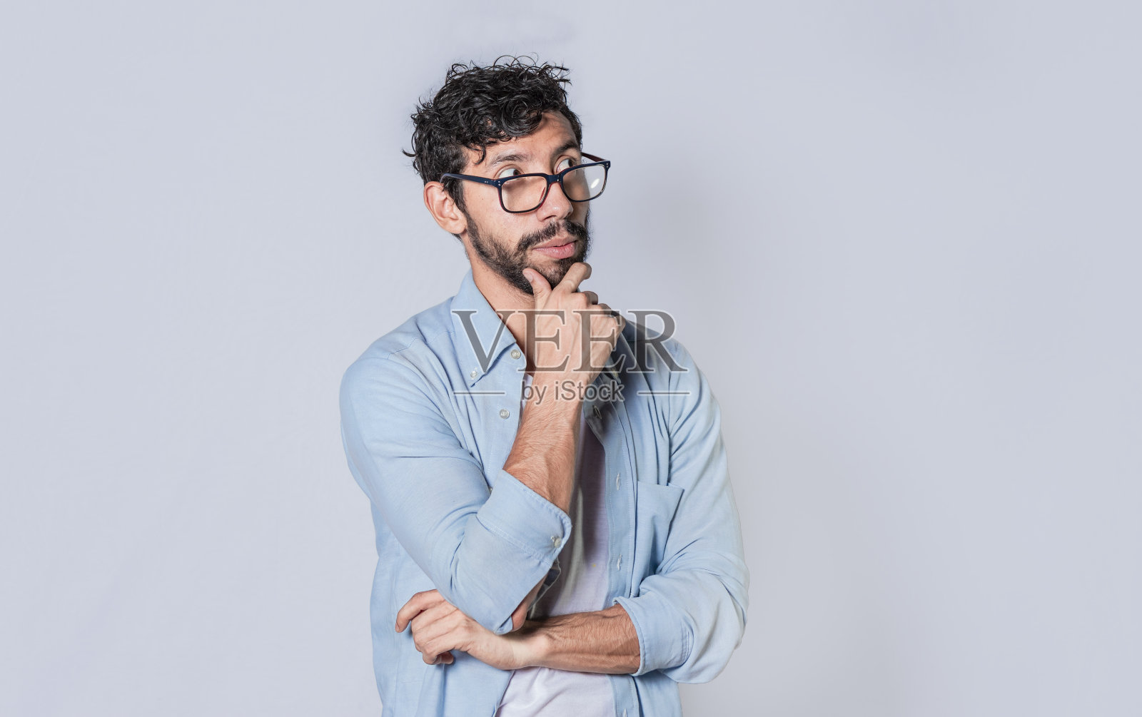 一个年轻人把手放在下巴上思考，另一个人把手放在下巴上思考。照片摄影图片