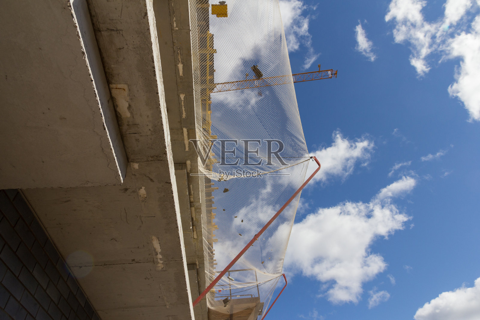 建筑安全网。防止物体从正在施工的建筑物上坠落的施工网。施工网安装在建筑的上层照片摄影图片