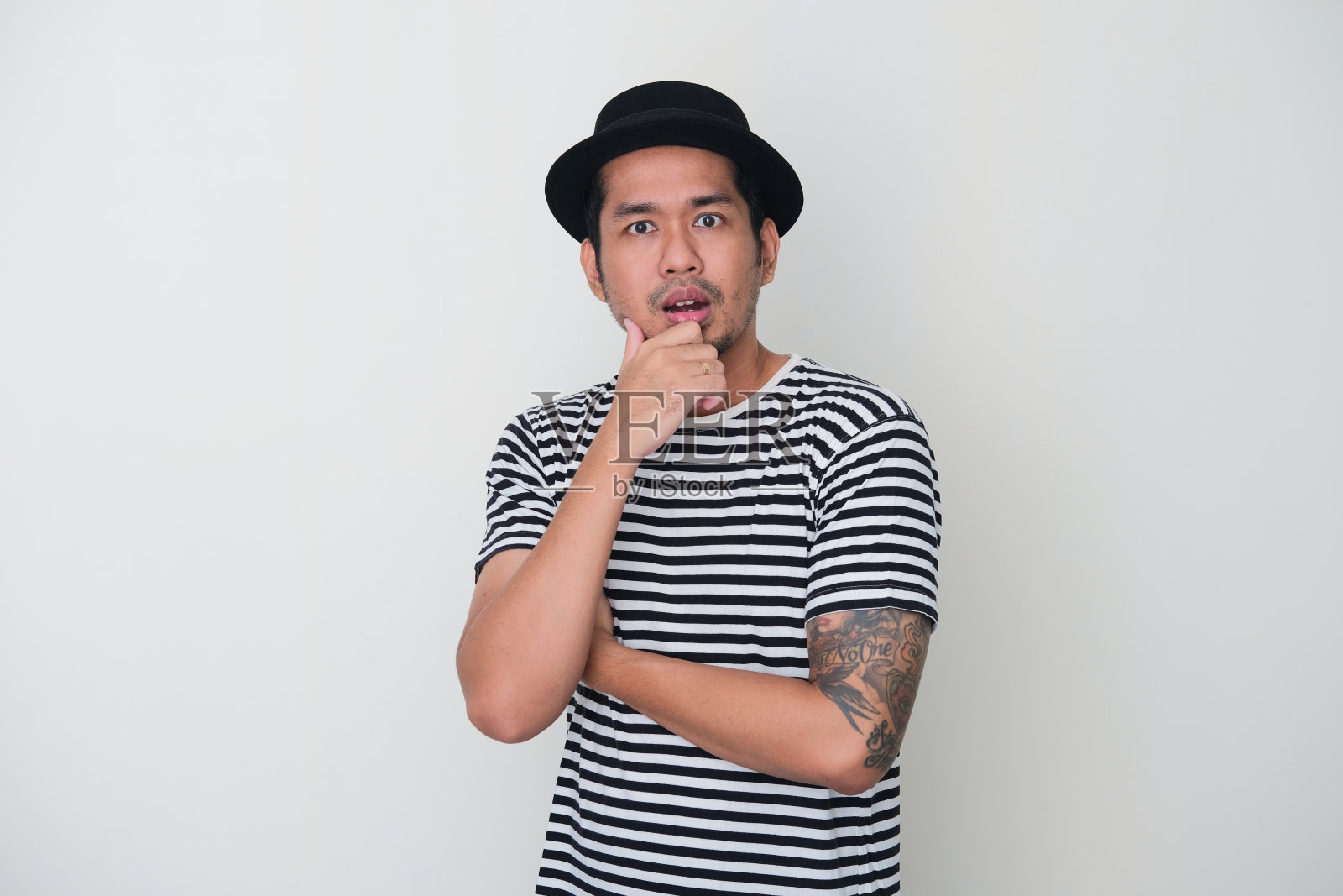 纹着纹身的亚洲男子看着镜头时露出了震惊的表情照片摄影图片