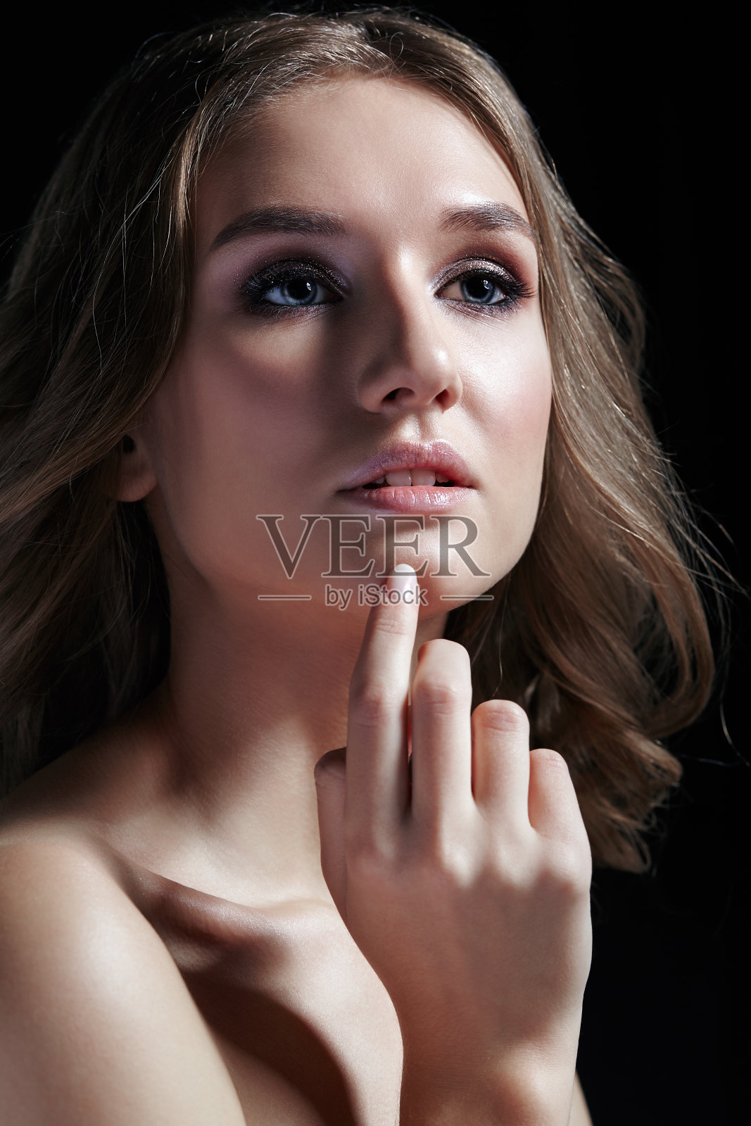 女性，黑色背景的波浪头发照片摄影图片